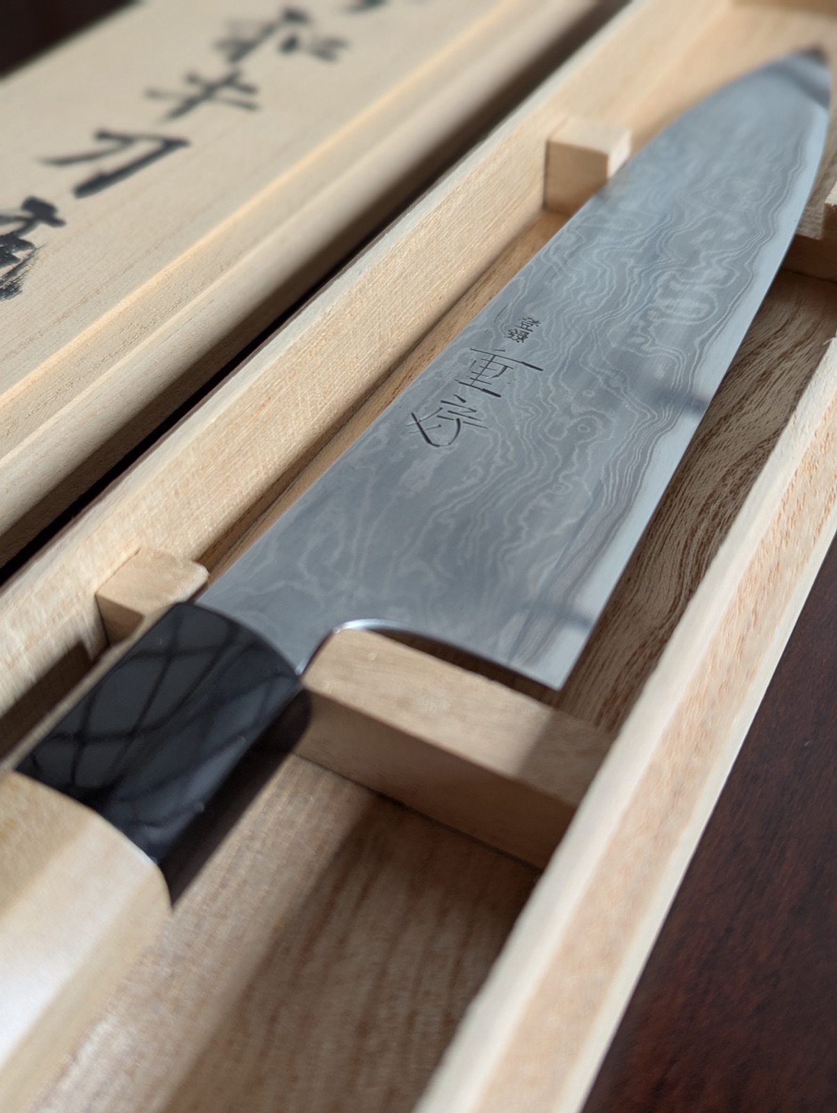 Close-up of the Shigefusa blade showing kitaeji damascus pattern and hand-chiseled kanji